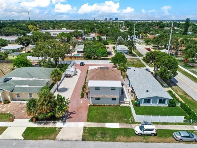 an aerial view of residential houses with outdoor space and ocean view