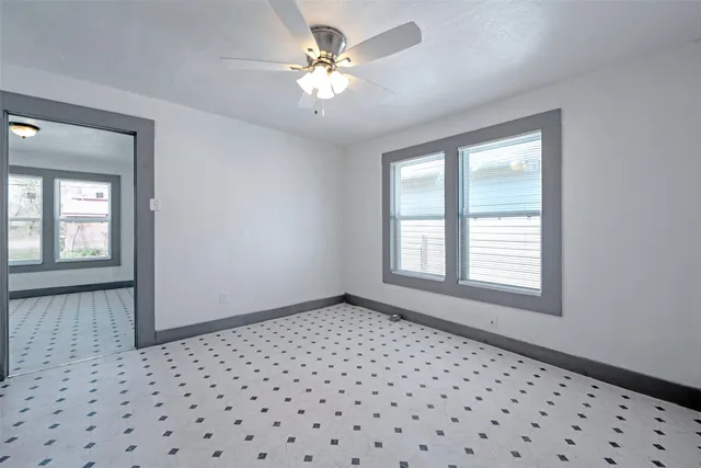 a view of a livingroom with a chandelier fan and windows