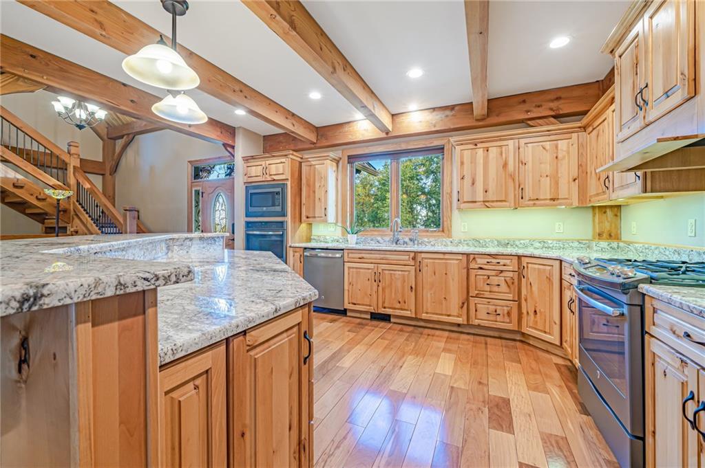 2780 Ipnar Road Irwin, PA 15642 - Photo 17 of 49 a kitchen with stainless steel appliances granite countertop a sink a stove and a wooden floors