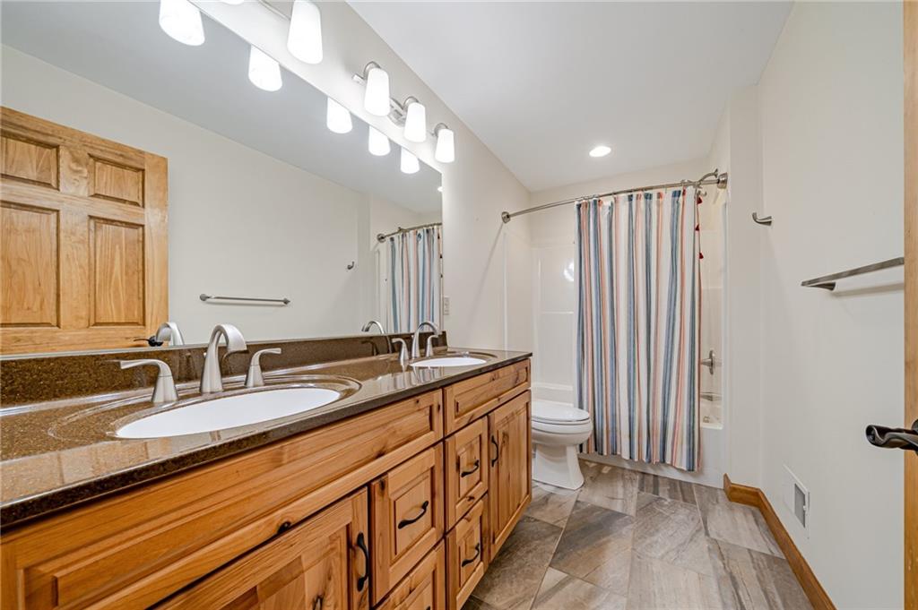2780 Ipnar Road Irwin, PA 15642 - Photo 25 of 49 a bathroom with a granite countertop sink a toilet and a large mirror