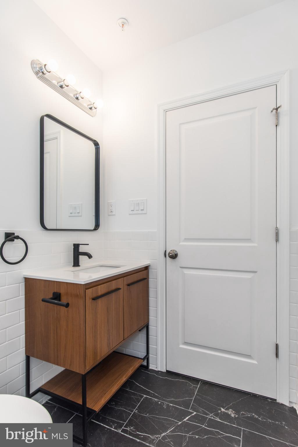 315 North Preston Street, Unit 101 Philadelphia, PA 19104 - Photo 21 of 26 a bathroom with a sink a mirror and vanity
