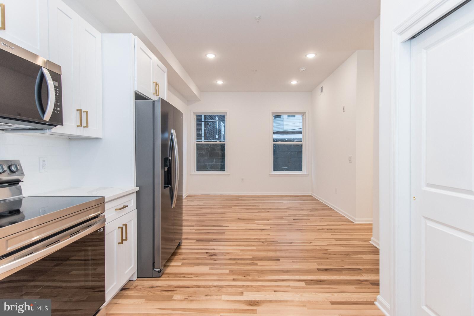 315 North Preston Street, Unit 101 Philadelphia, PA 19104 - Photo 4 of 26 a kitchen with stainless steel appliances granite countertop a refrigerator and a stove top oven