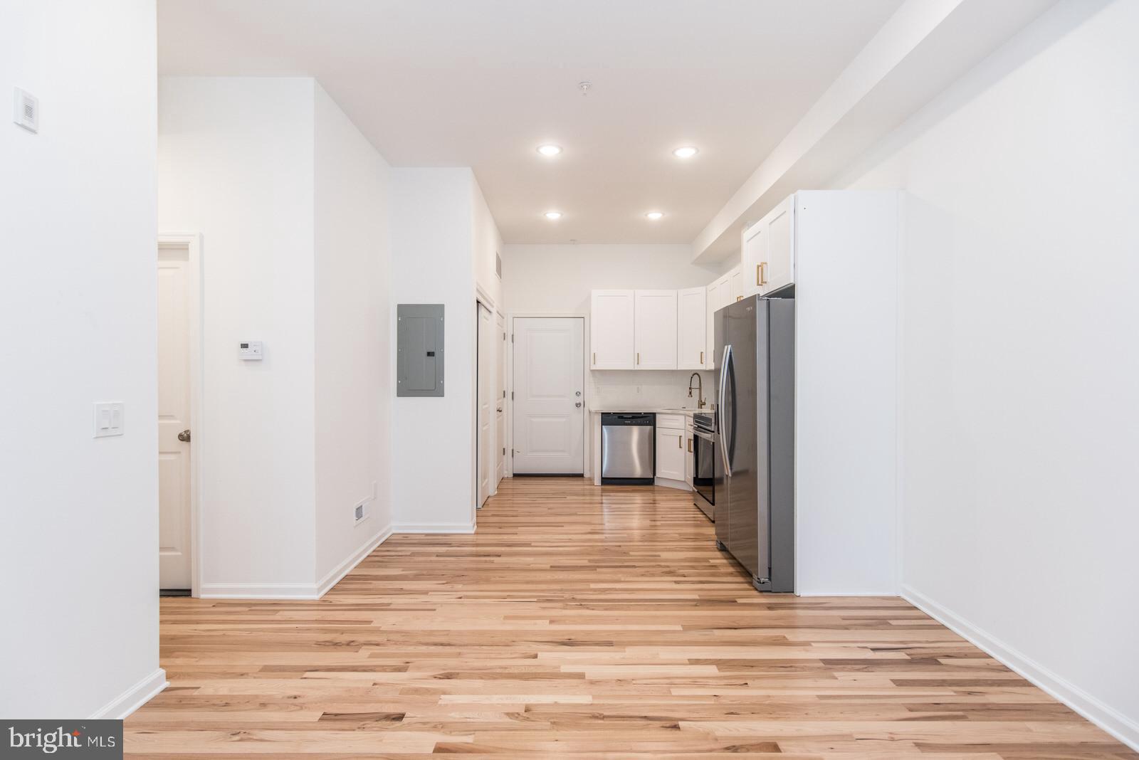315 North Preston Street, Unit 101 Philadelphia, PA 19104 - Photo 5 of 26 a view of a kitchen with a refrigerator and an empty room