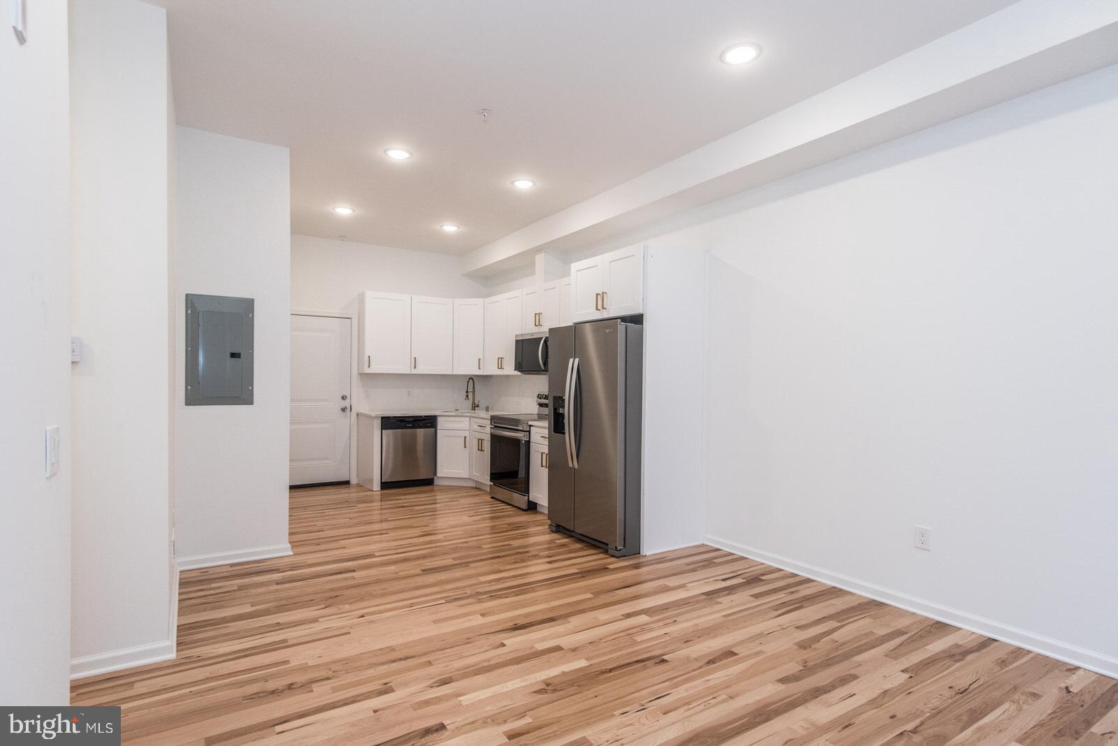 315 North Preston Street, Unit 101 Philadelphia, PA 19104 - Photo 6 of 26 a view of a kitchen with a refrigerator and a stove top oven