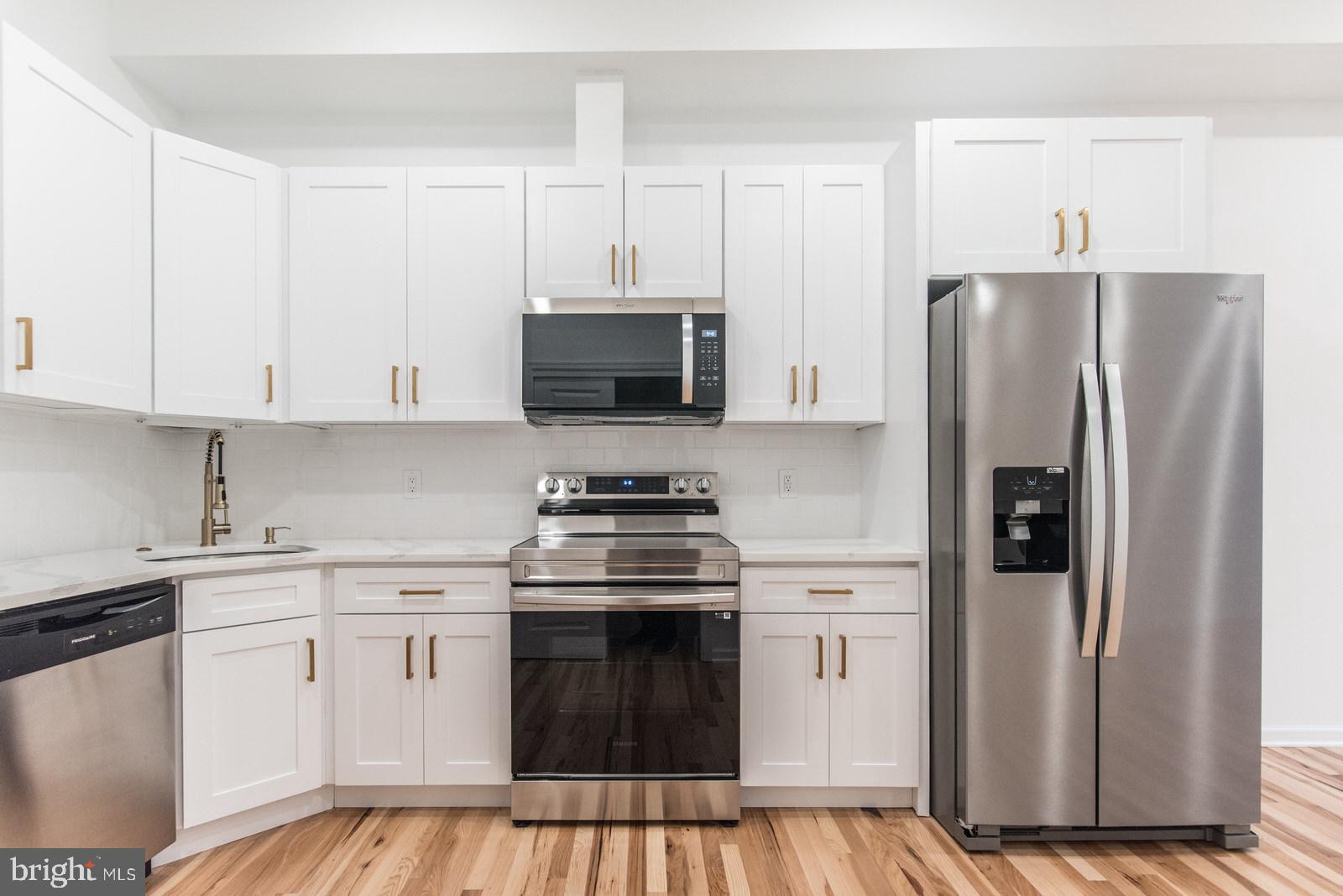 315 North Preston Street, Unit 101 Philadelphia, PA 19104 - Photo 9 of 26 a kitchen with stainless steel appliances a refrigerator stove and white cabinets