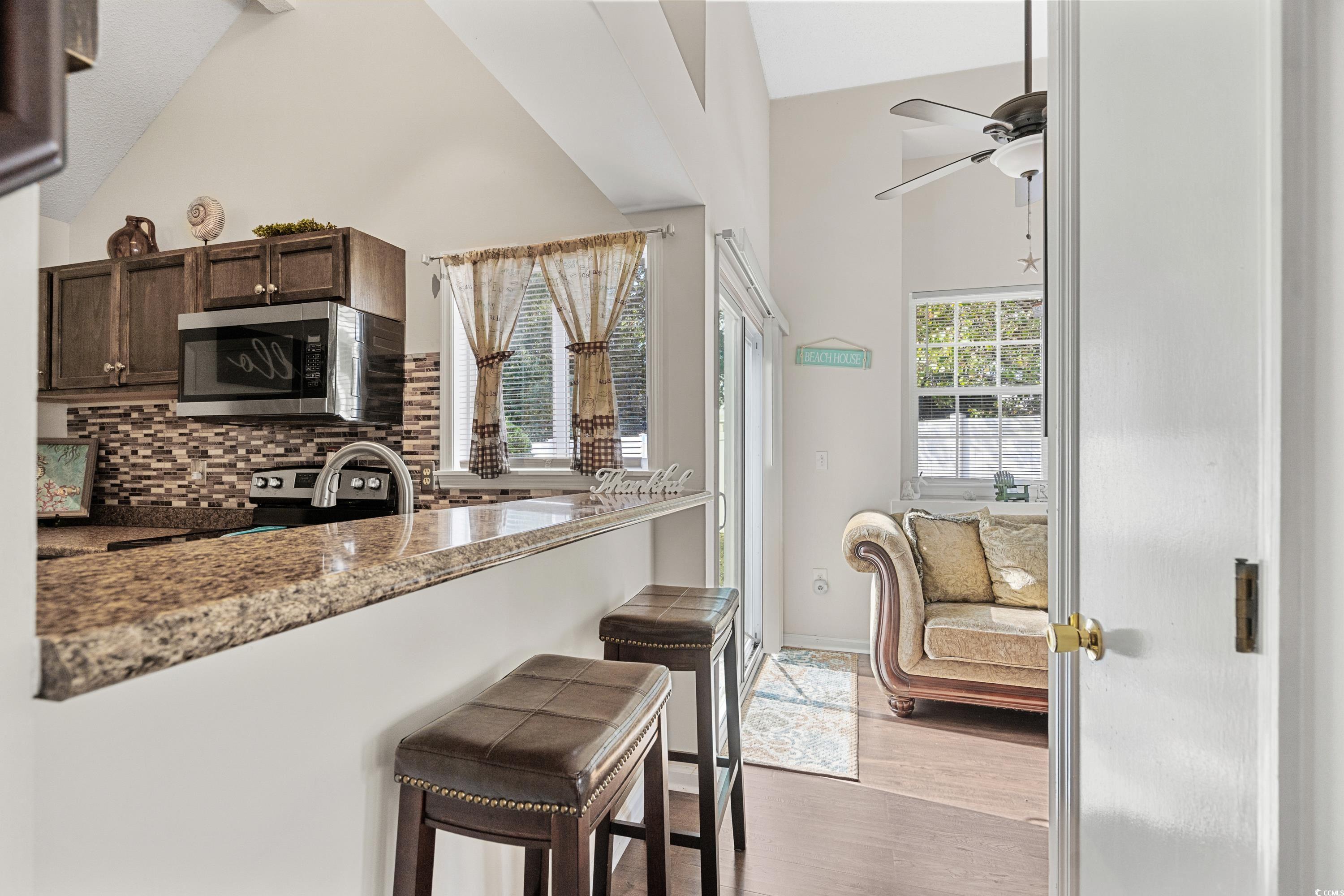 133 Whitehaven Court Myrtle Beach, SC 29577 - Photo 20 of 31 Kitchen with dark brown cabinets, light hardwood /