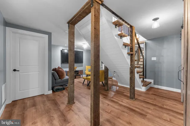 a view of a hallway with wooden floor and furniture