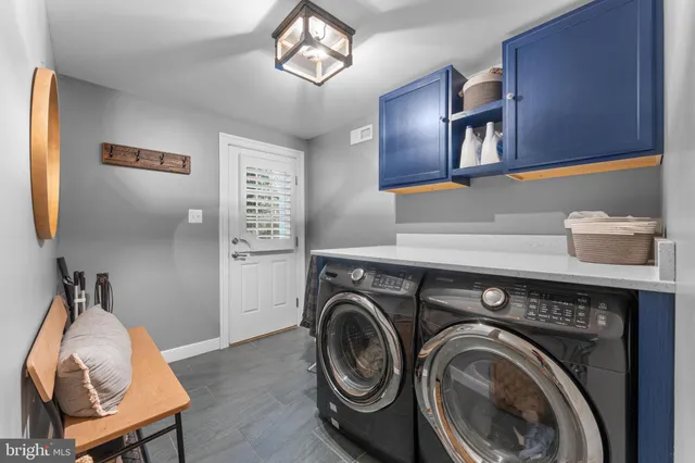 a utility room with cabinets dryer and washer