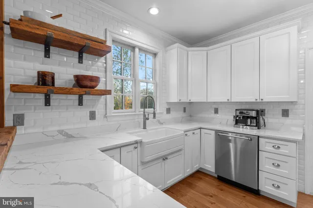 a kitchen with a sink dishwasher and cabinets with wooden floor