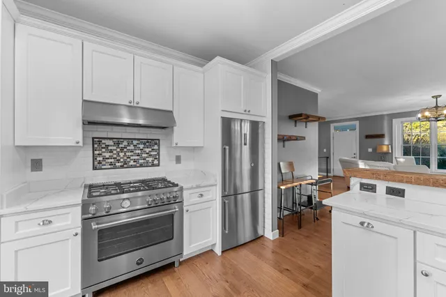 a kitchen with cabinets stainless steel appliances and wooden floor