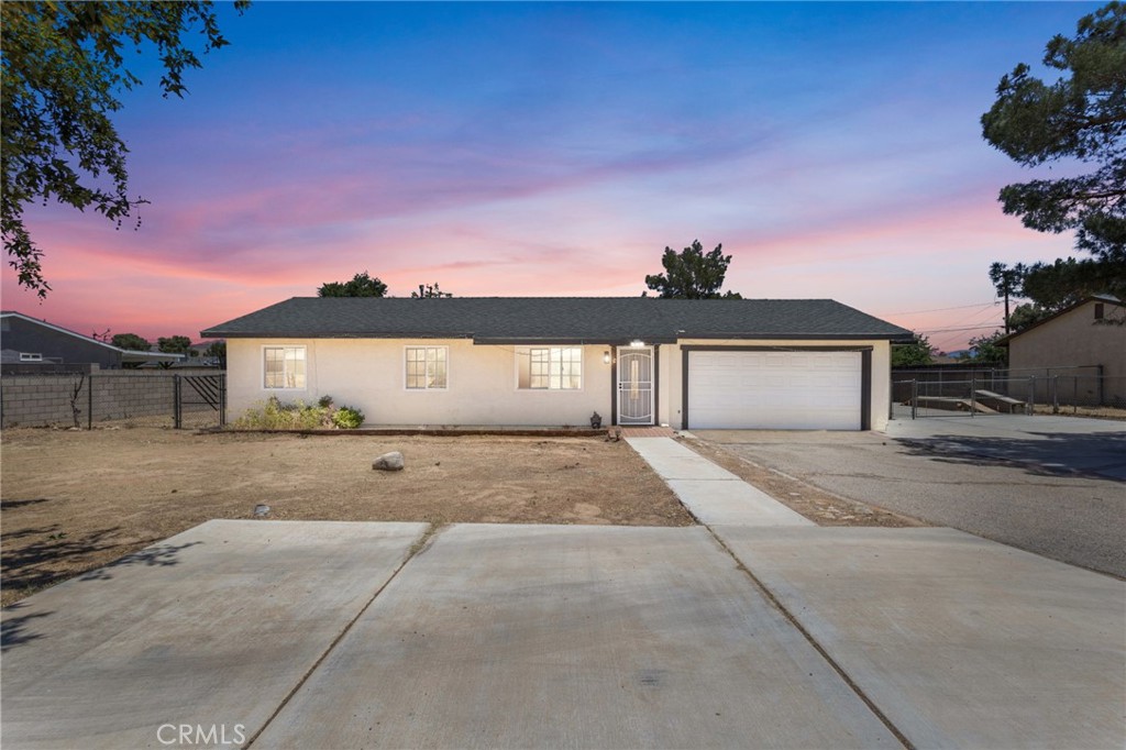15471 Washoan Road Apple Valley, CA 92307 - Photo 1 of 38 a front view of a house with a yard and garage