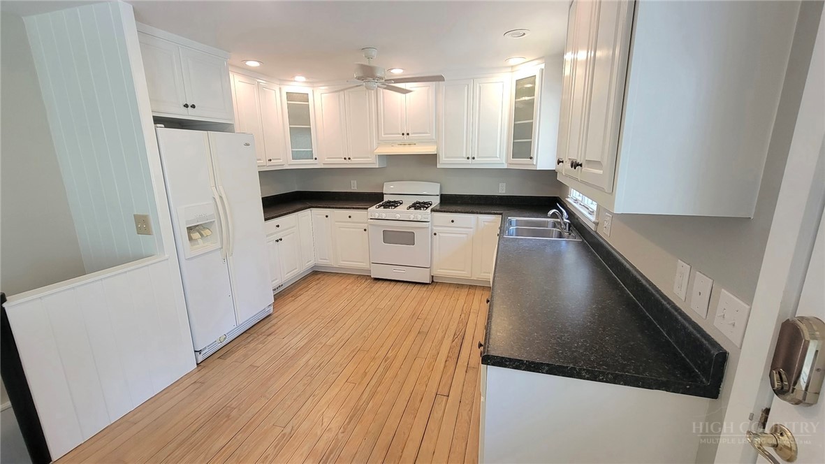 172 Yarrow Lane Boone, NC 28607 - Photo 7 of 30 a kitchen with a sink a stove a refrigerator and white cabinets