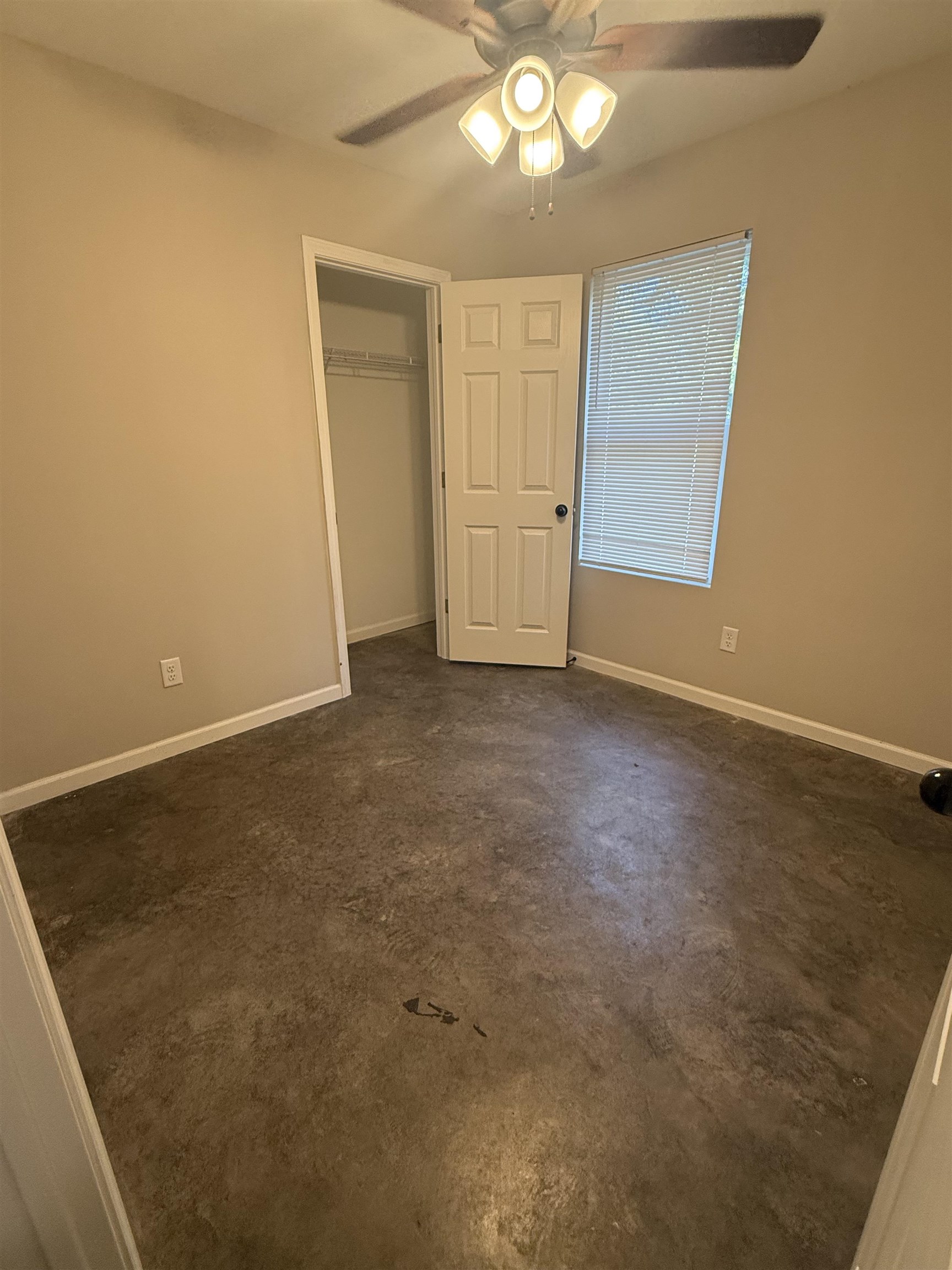 4589 Range Line Road Memphis, TN 38127 - Photo 18 of 25 Unfurnished bedroom featuring ceiling fan, a closet, and concrete flooring