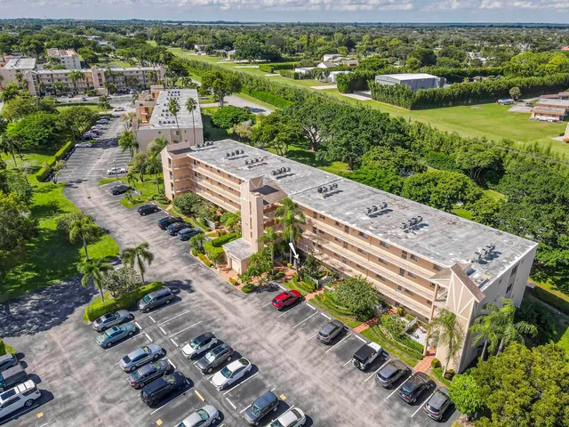 an aerial view of a house with a garden and lake view
