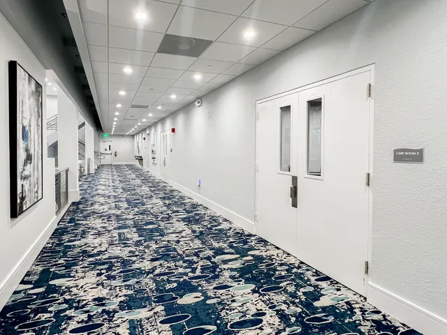 a living room with stainless steel appliances furniture pool table and a flat screen tv