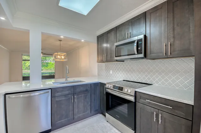 a kitchen with granite countertop cabinets stainless steel appliances and microwave