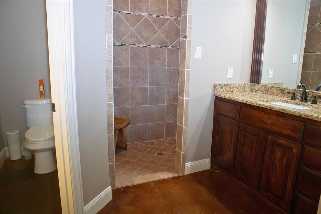 7115 Sussex Lane Mansfield, TX 76063 - Photo 13 of 25 a bathroom with a granite countertop sink a toilet and a shower