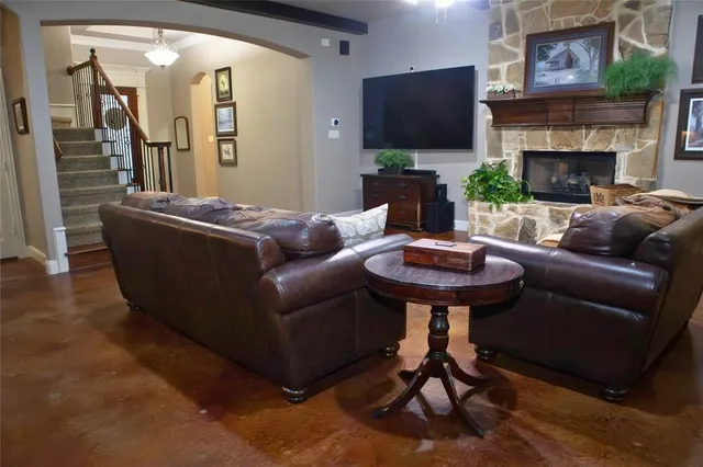 a living room with furniture a flat screen tv and a fireplace