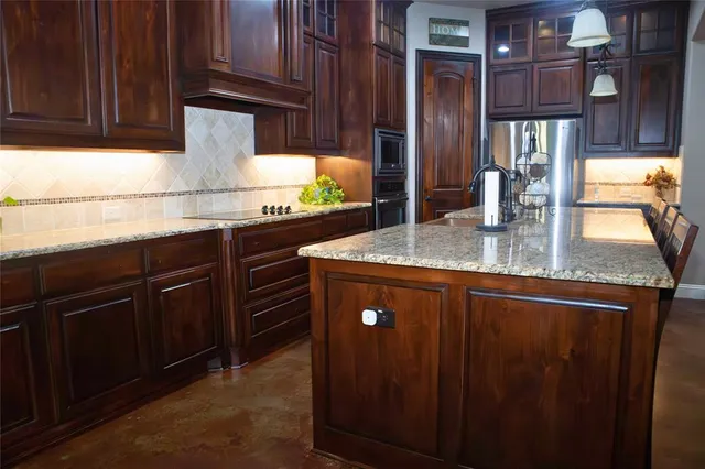 a kitchen with stainless steel appliances granite countertop wooden cabinets a sink and dishwasher