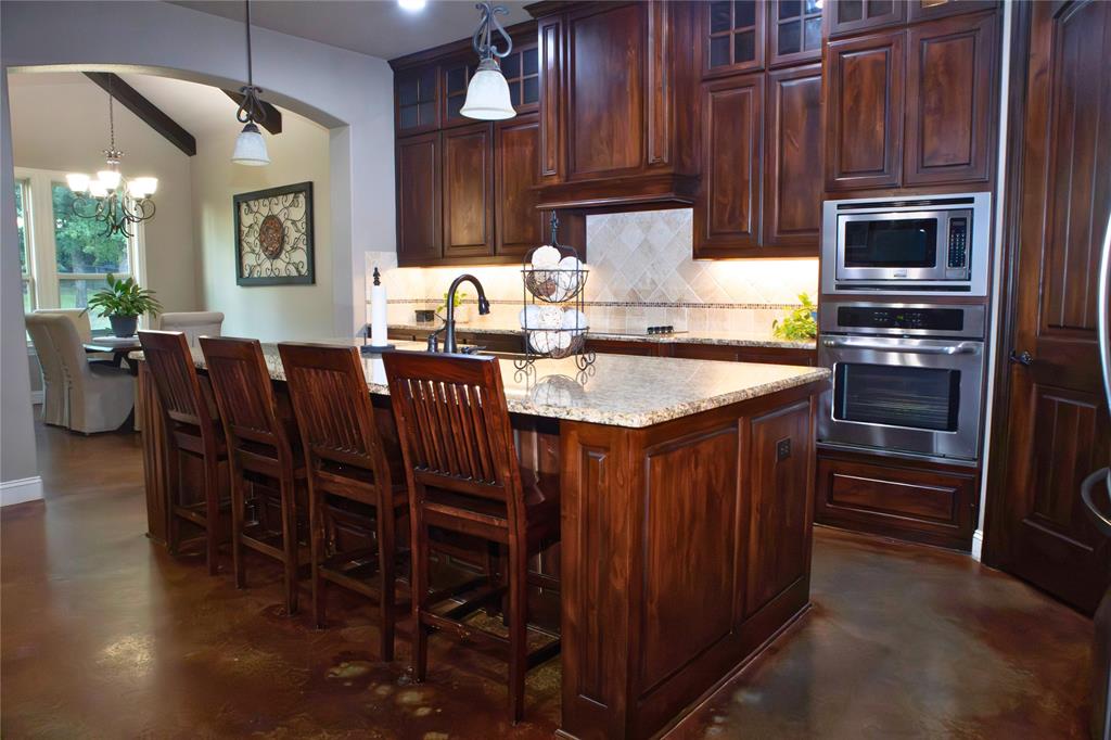 7115 Sussex Lane Mansfield, TX 76063 - Photo 8 of 25 a kitchen with stainless steel appliances granite countertop a table chairs sink and cabinets