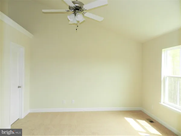 an empty room with a window and a fan