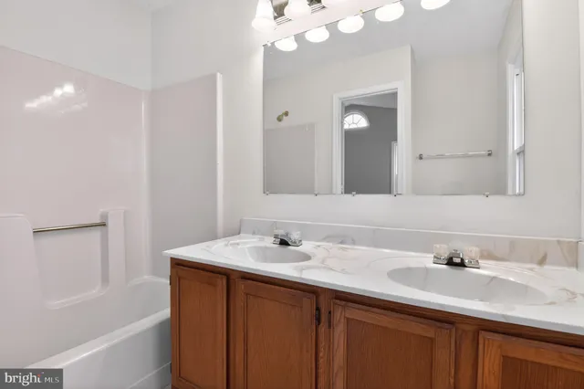 a bathroom with a sink vanity tub and a mirror