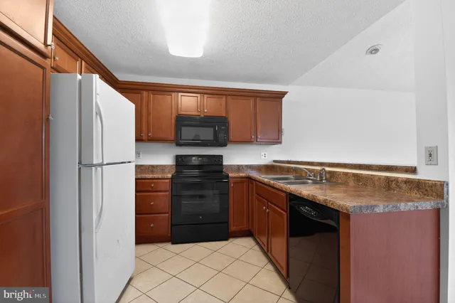 a kitchen with stainless steel appliances granite countertop a refrigerator and a stove