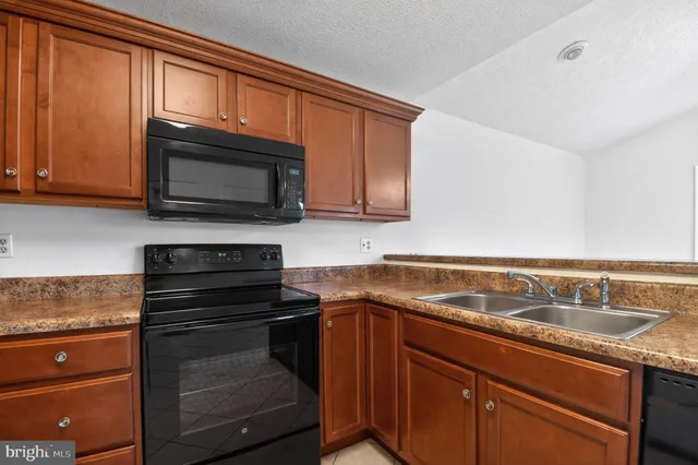 a kitchen with granite countertop wooden cabinets and a stove top oven