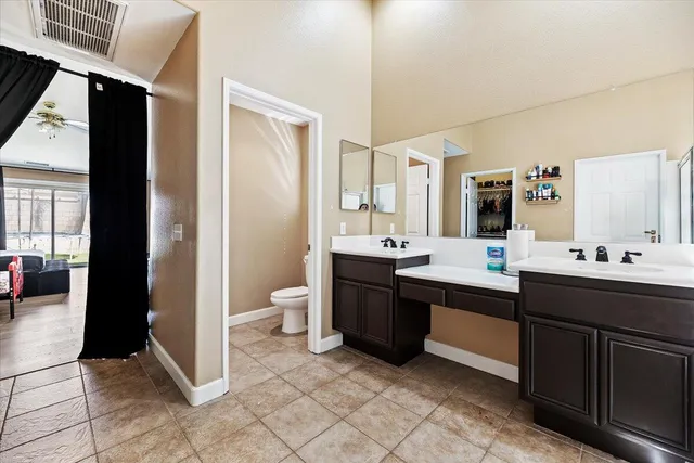a spacious bathroom with a double vanity sink toilet and shower