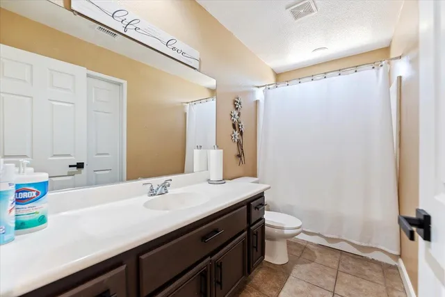 a bathroom with a sink a toilet a mirror and shower