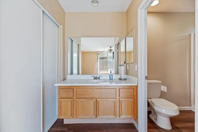 a bathroom with a sink a toilet a mirror and vanity