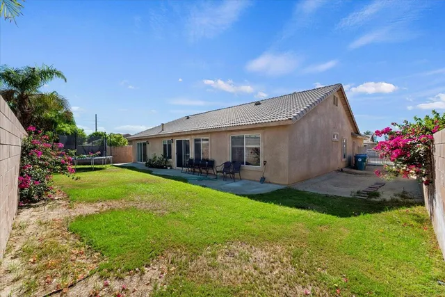 a view of a house with backyard and sitting area