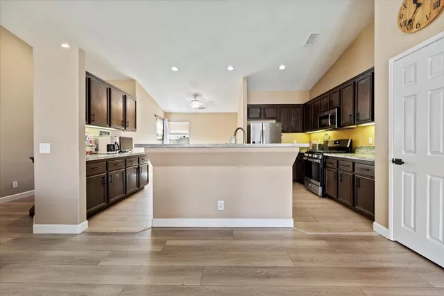 a large kitchen with stainless steel appliances and a refrigerator