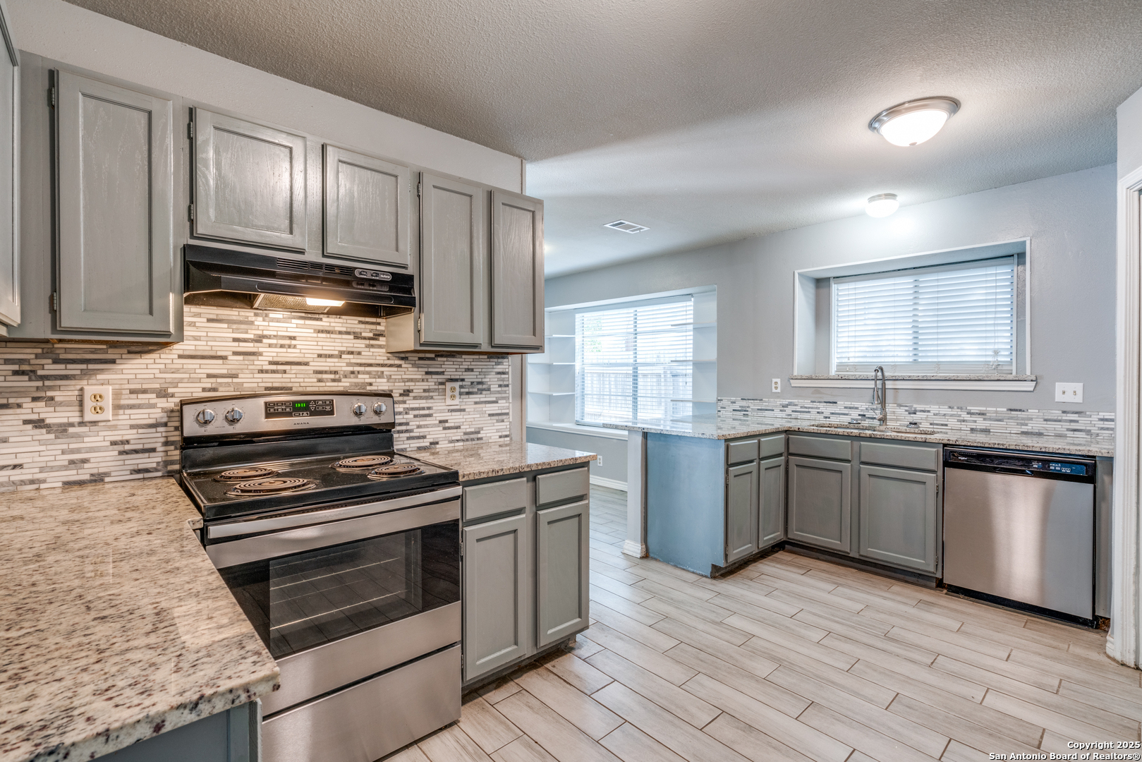 8009 Forest Ash Live Oak, TX 78233 - Photo 11 of 33 a kitchen with granite countertop wooden cabinets stainless steel appliances and a window
