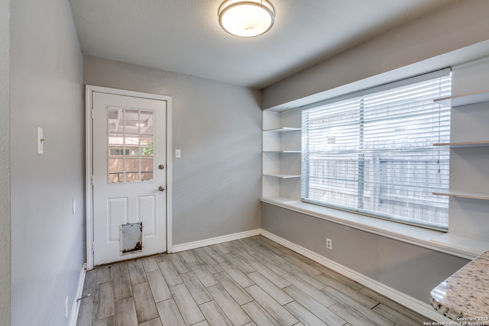 8009 Forest Ash Live Oak, TX 78233 - Photo 14 of 33 a view of an empty room with wooden floor and a window