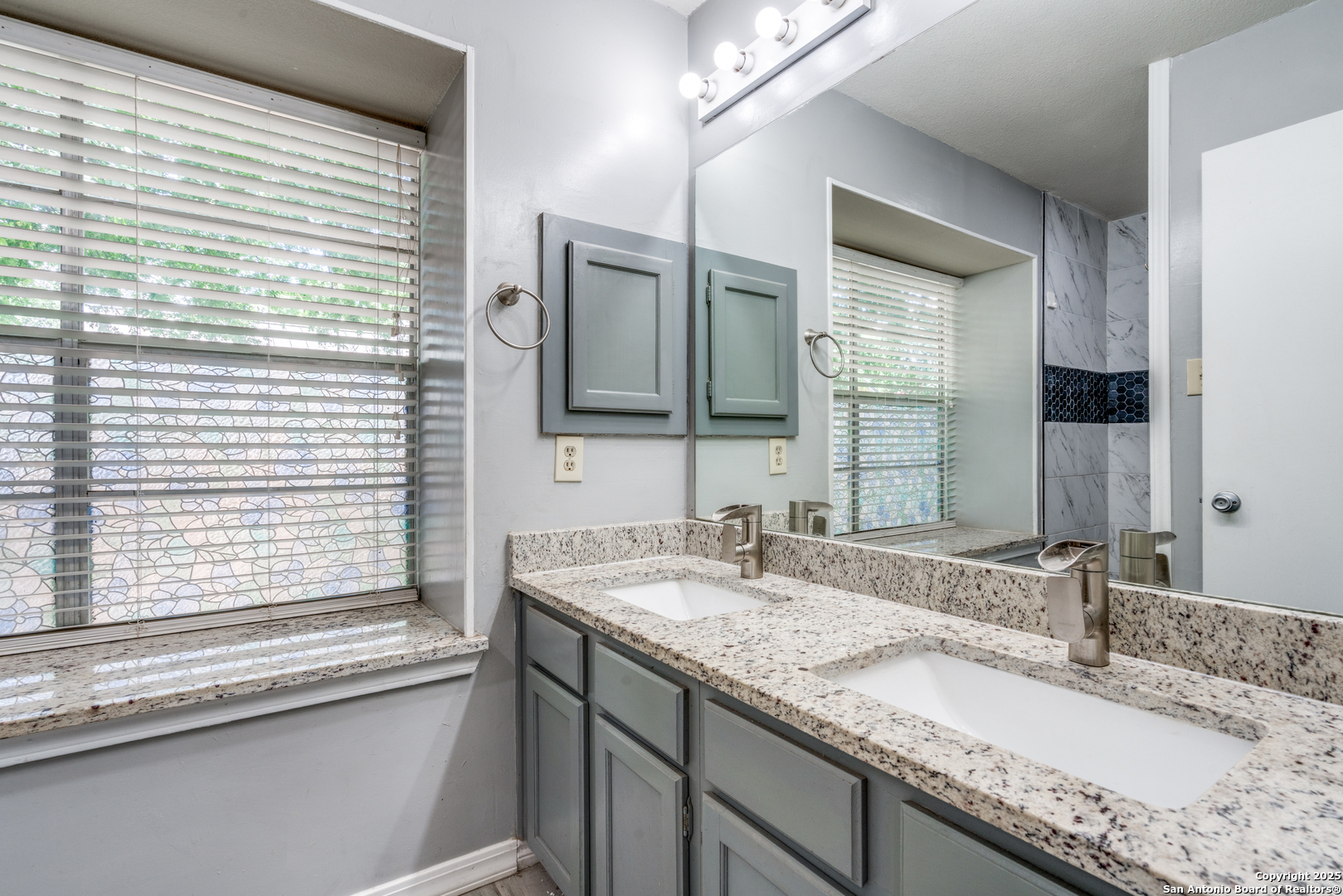 8009 Forest Ash Live Oak, TX 78233 - Photo 18 of 33 a bathroom with a granite countertop sink and a large mirror