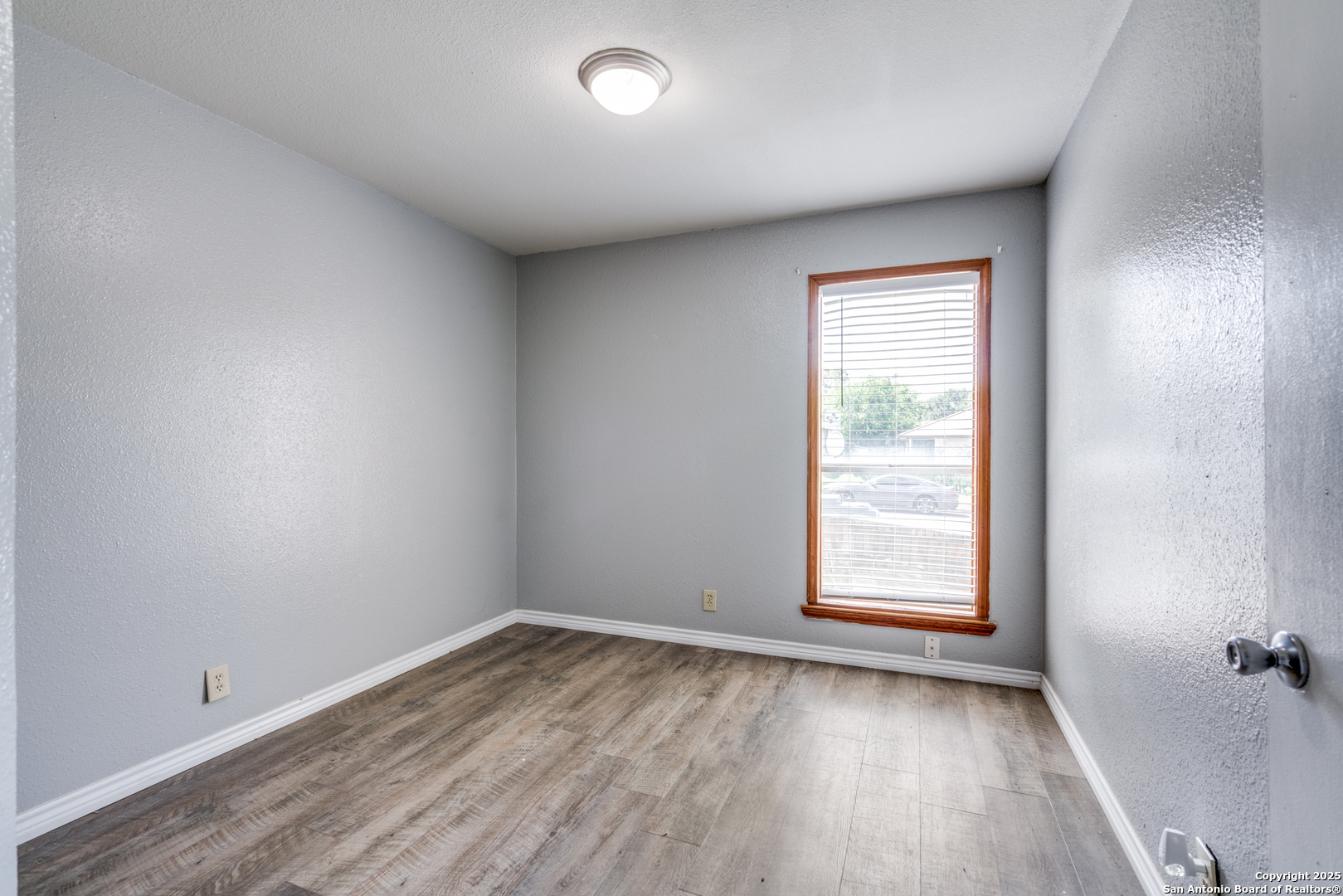 8009 Forest Ash Live Oak, TX 78233 - Photo 22 of 33 an empty room with wooden floor and windows