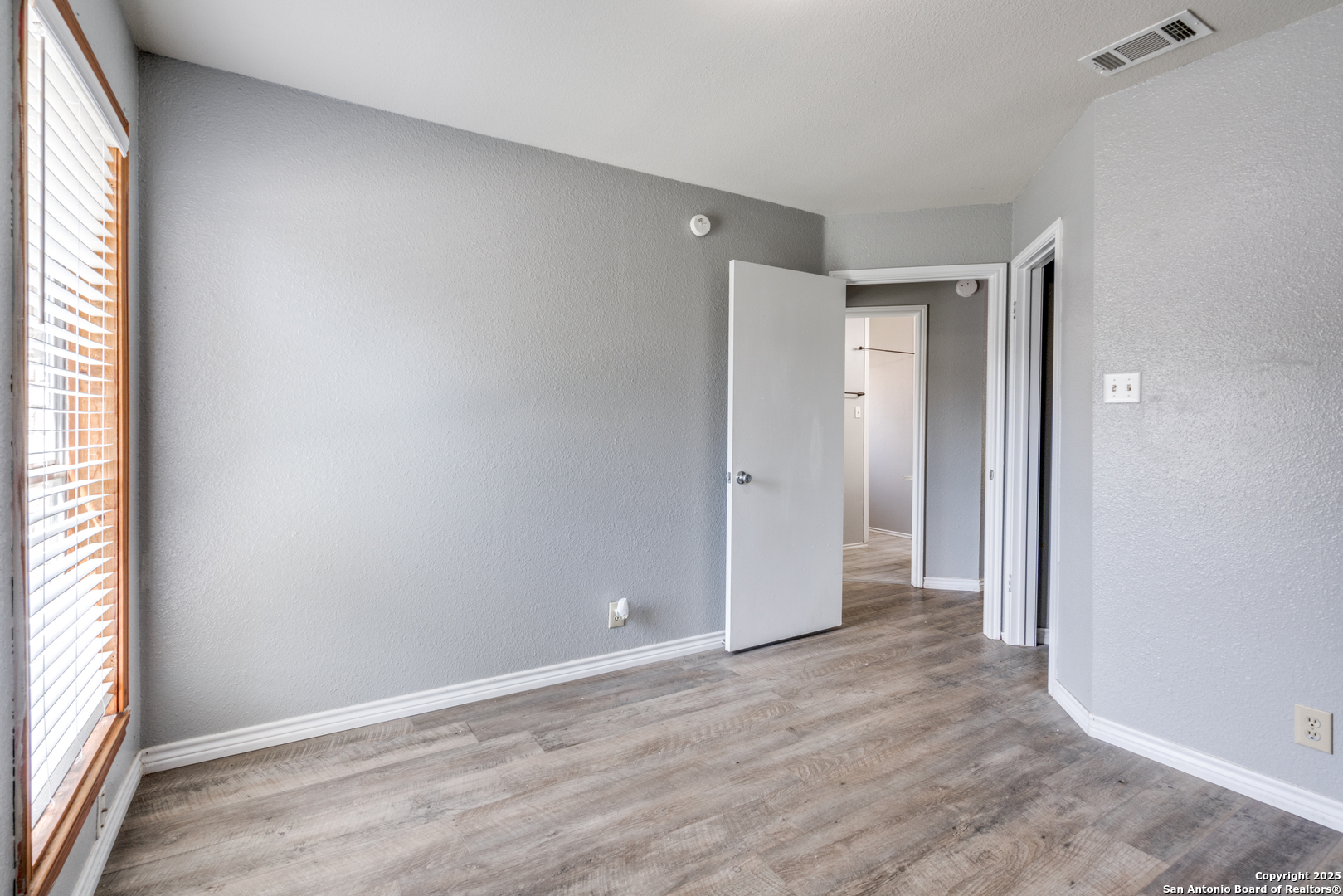 8009 Forest Ash Live Oak, TX 78233 - Photo 23 of 33 an empty room with wooden floor and windows