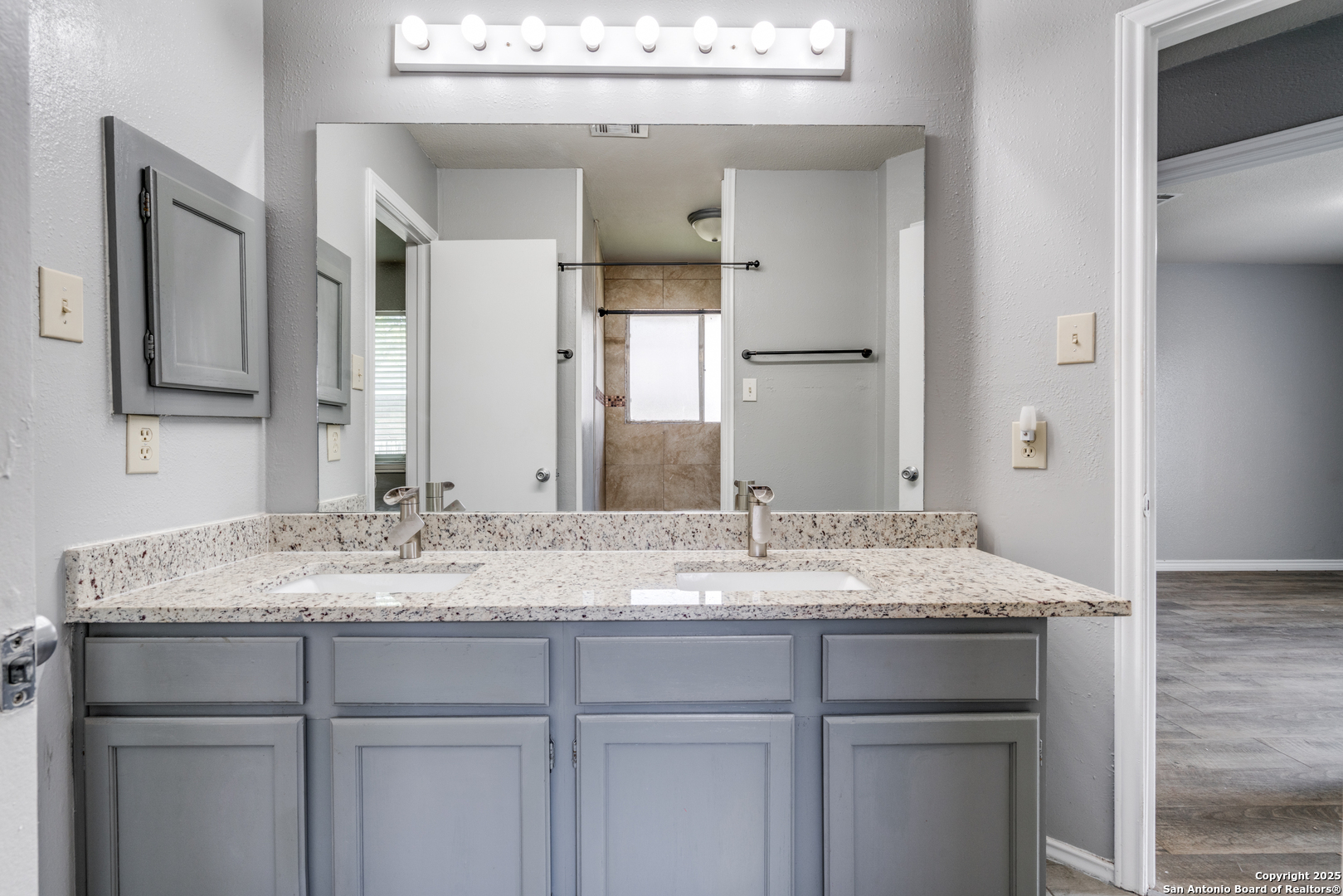 8009 Forest Ash Live Oak, TX 78233 - Photo 28 of 33 a bathroom with a granite countertop sink and a mirror