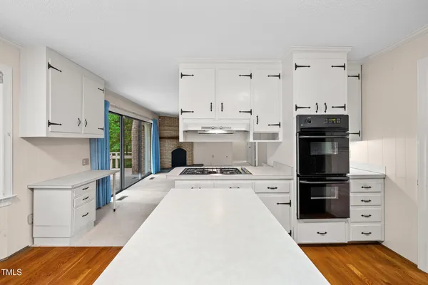 a view of a hallway with wooden floor and entryway