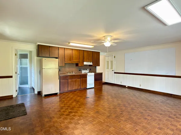 a view of a yard with plants and large trees