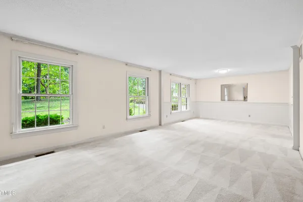 a view of an empty room with a fireplace and a window