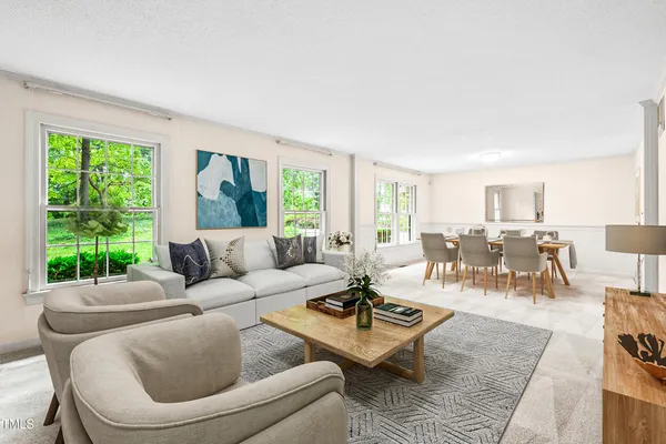 a living room with furniture a fireplace and a floor to ceiling window