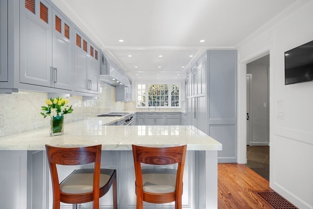 89 Ledgeways Wellesley, MA 02481 - Photo 13 of 42 a kitchen with kitchen island granite countertop furniture and a wooden floor