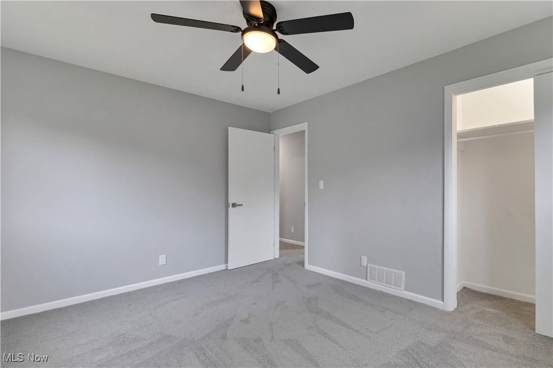 3071 Call Road Stow, OH 44224 - Photo 14 of 25 Unfurnished bedroom featuring ceiling fan, a closet, light carpet, and a walk in closet