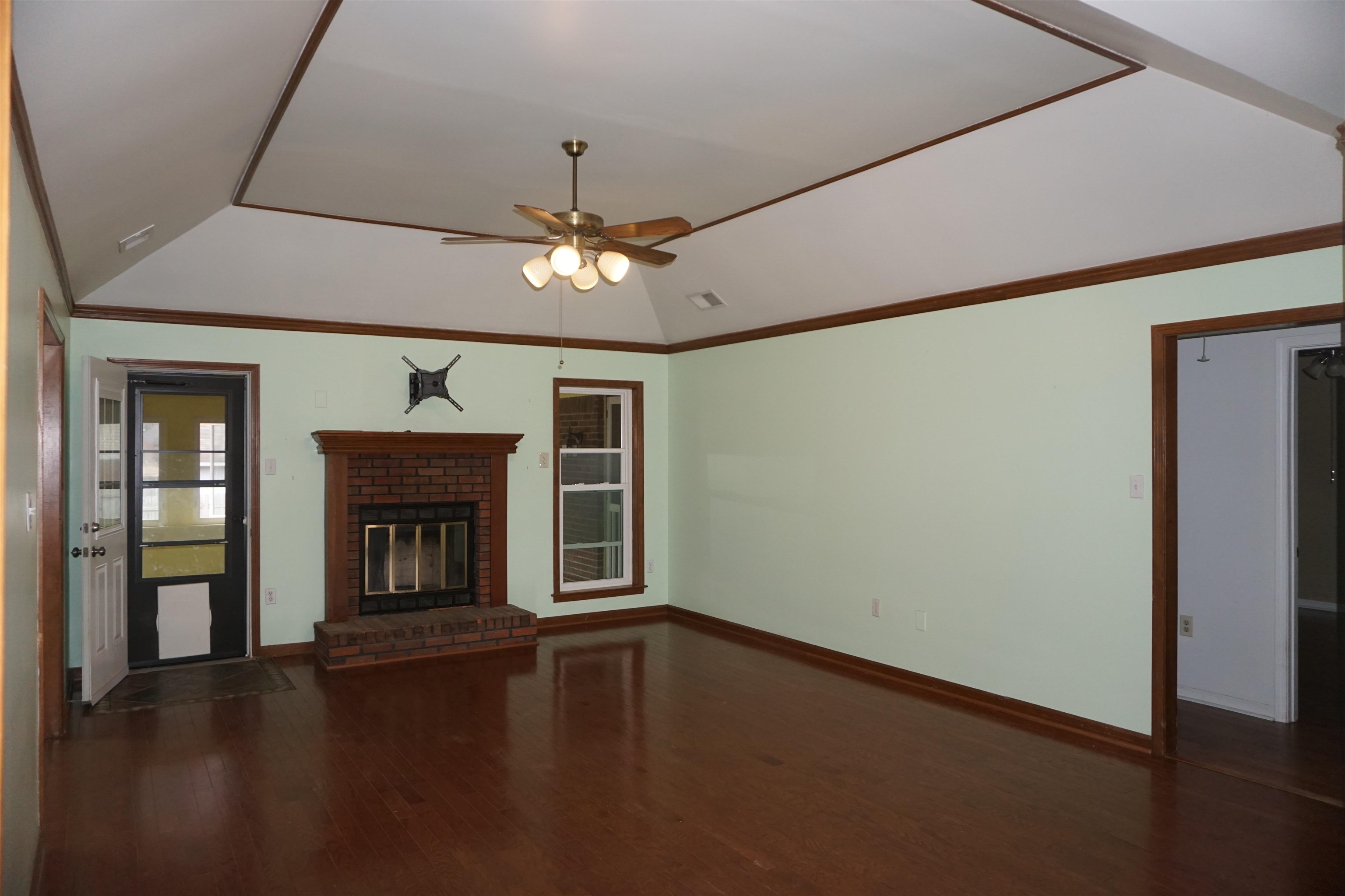 6320 Yale Road Bartlett, TN 38134 - Photo 3 of 25 an empty room with windows fireplace and wooden floor
