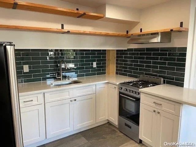 a kitchen with white cabinets and appliances