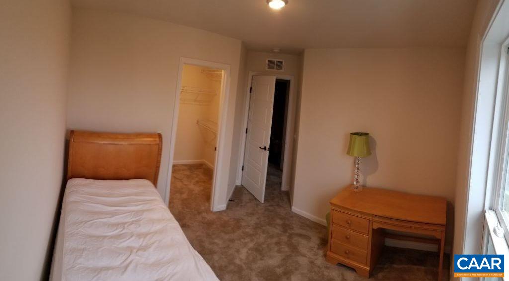 2180 Avinity Loop Charlottesville, VA 22902 - Photo 23 of 32 a bedroom with a bed and wooden floor