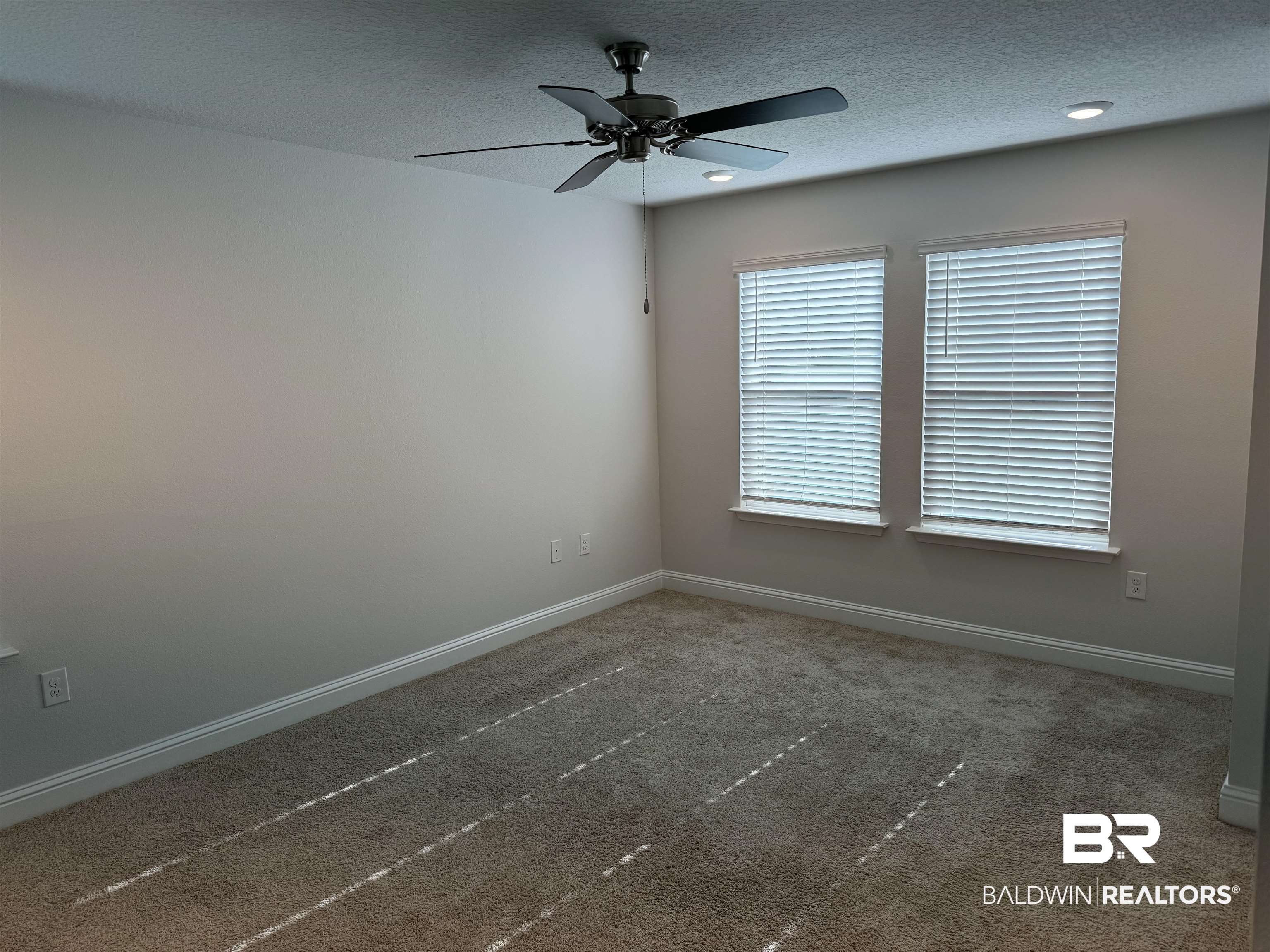 25806 Pollard Road, Unit 42 Daphne, AL 36526 - Photo 12 of 21 Empty room featuring dark colored carpet, ceiling fan, and a textured ceiling