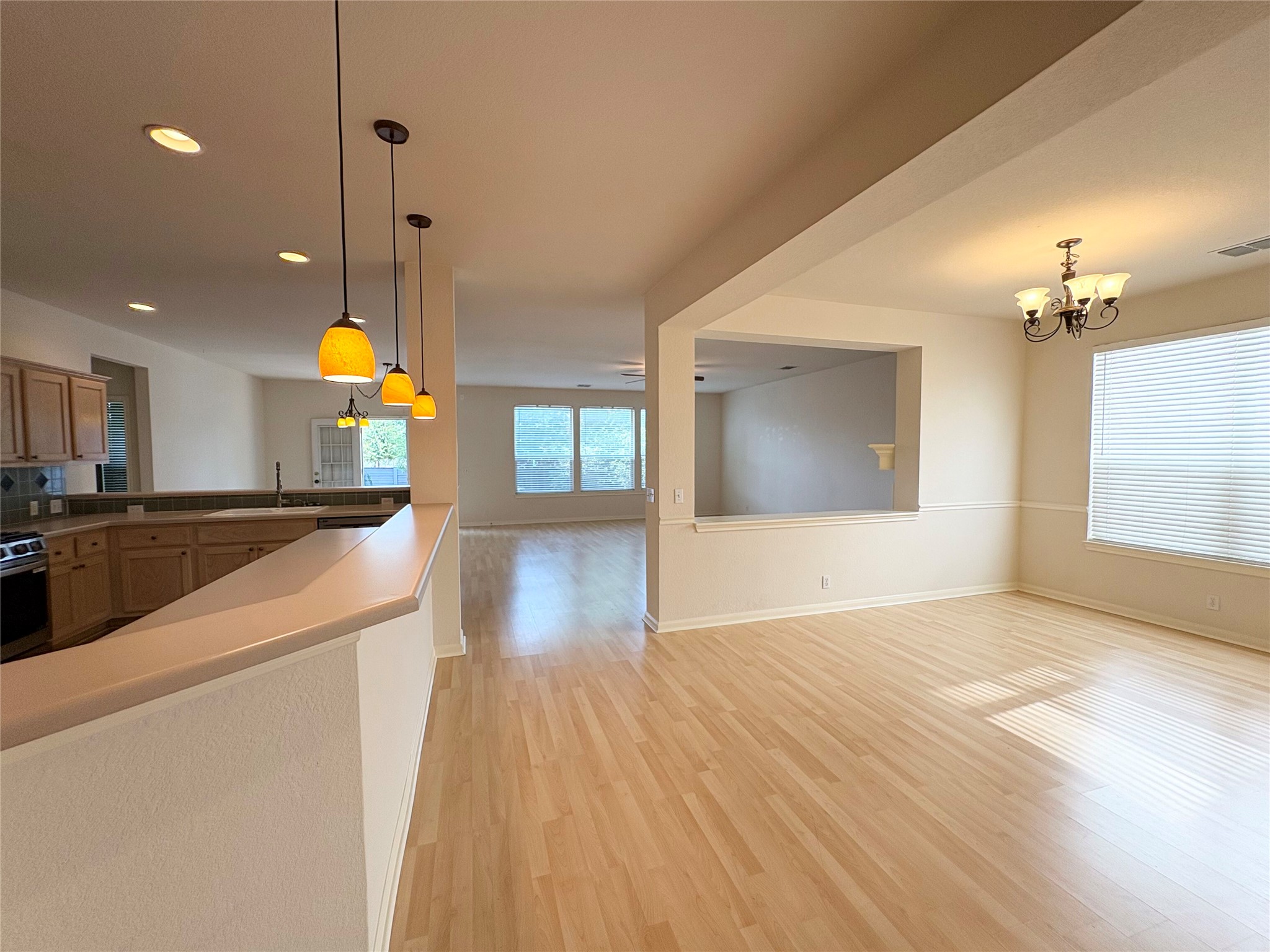 7006 Rambollet Terrace Round Rock, TX 78681 - Photo 37 of 38 An open floor plan with hardwood flooring connects the dining room and kitchen.